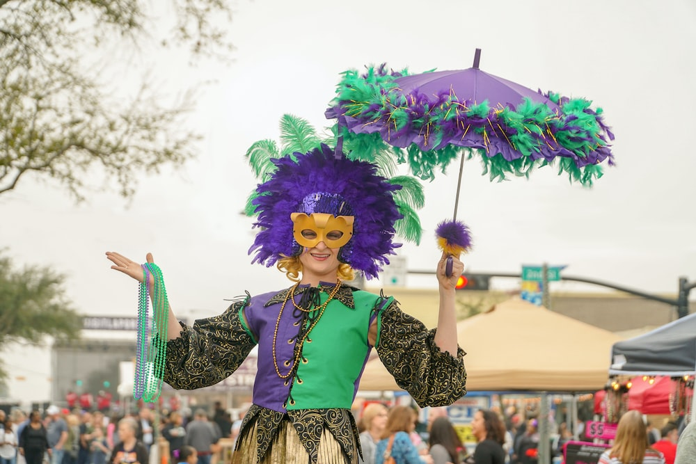 A person wearing purple, green, and gold colors