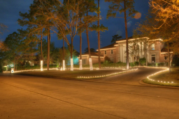 landscape lights on the base of the trees, pathways, and house’s roof