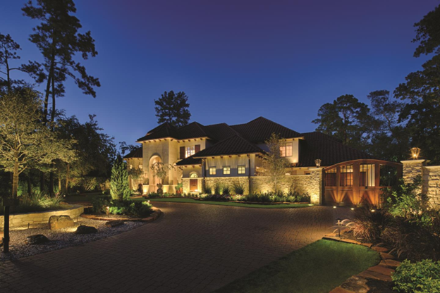 Landscape lighting illuminating the exterior of a house during the night 