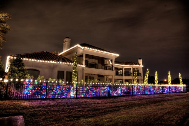 A big house covered in blue, red, and white lights.
