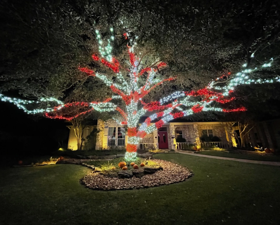 Professional exterior lighting installation illuminating a Houston home for an event.